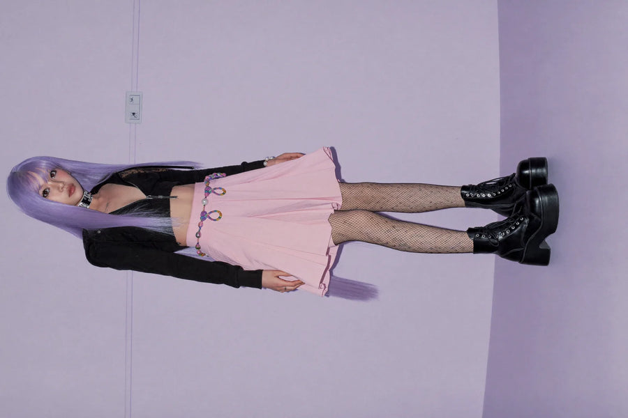 Pastel goth outfit with lavender hair, black cropped hoodie, pastel pink pleated skirt and platform boots
