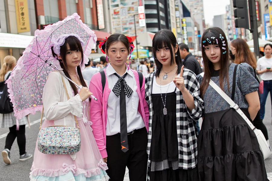Four people in different Japanese alternative fashion styles: Lolita, Jirai Kei, Visual Kei and Decora