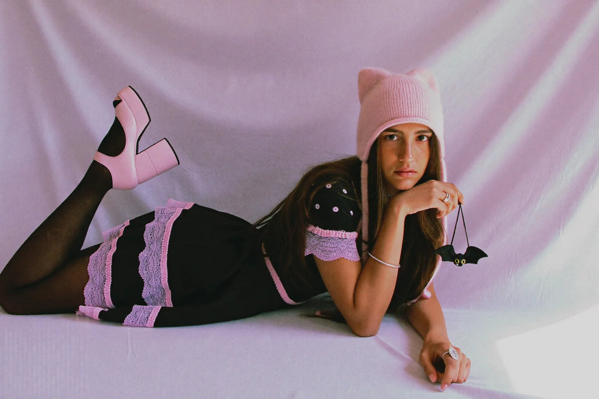 Kawaii goth outfit with a black babydoll dress, pink lace trim, cat ear beanie and chunky platform Mary Janes